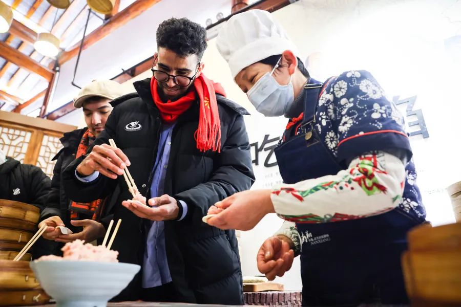 外国留学生体验小笼馒头制作。海沙尔摄