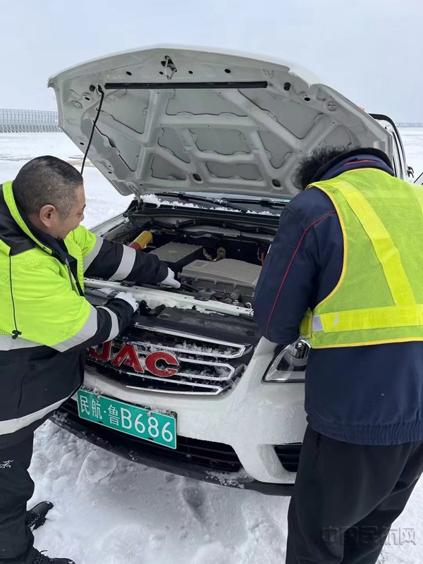 王济鹏(左)和同事在山东青岛胶东机场机坪,对新能源皮卡进行排故