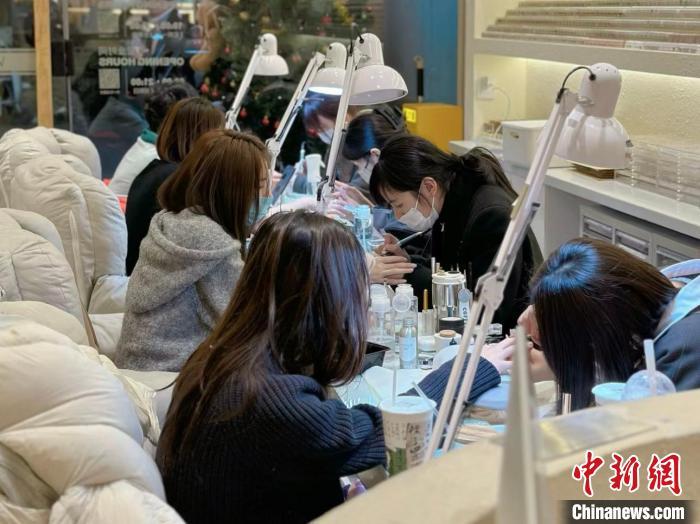 图为2月6日,晚上十一点,青海省西宁市城西区芷间日式美甲美睫店内坐满了来做美甲的顾客。刘洋摄
