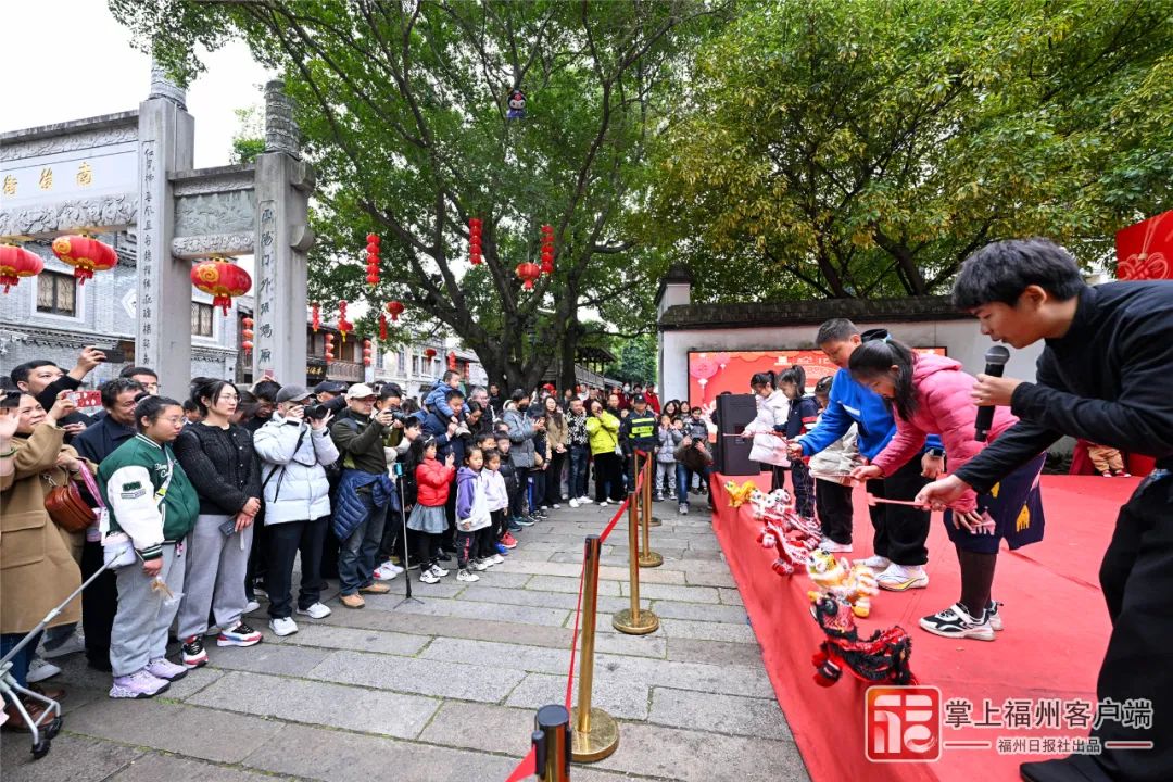 在三坊七巷旅游的游客体验非遗提线木偶戏。池远 摄