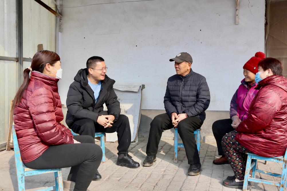 韓峰（左二）正與村民坐在一起拉家常。新華社記者高天 攝