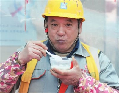 中建八局上海公司第二分公司承建的静安区安康苑一期项目上,来自江苏的束安奎吃着汤圆。摄影 倪修龙