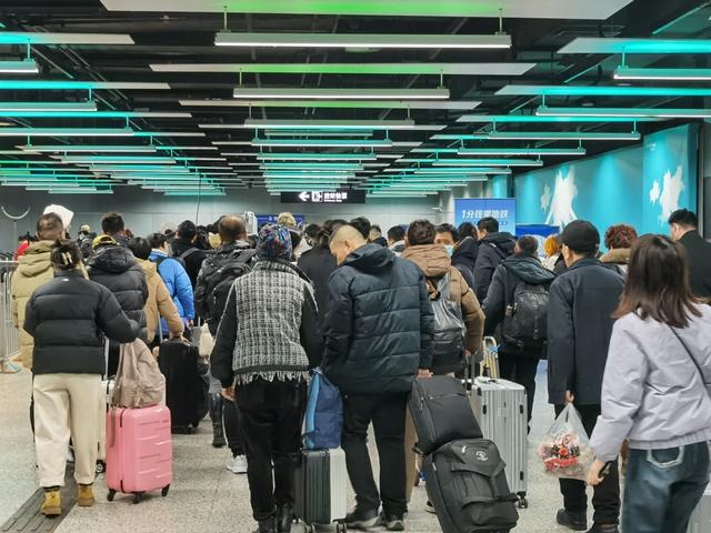 △长时间的排队后,等候安检的乘客队伍开始变乱,人群一窝蜂往前挤。