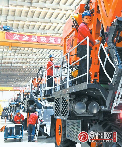 在铁建重工新疆有限公司农机总装车间，工人正在组装智能六行打包采棉机。