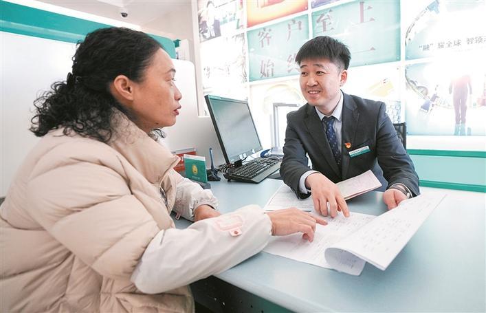 3月19日,在农行阿勒泰兵团分行一八三团支行,工作人员宋健(右)为团场职工办理“惠农e贷”业务。 李正虎 摄