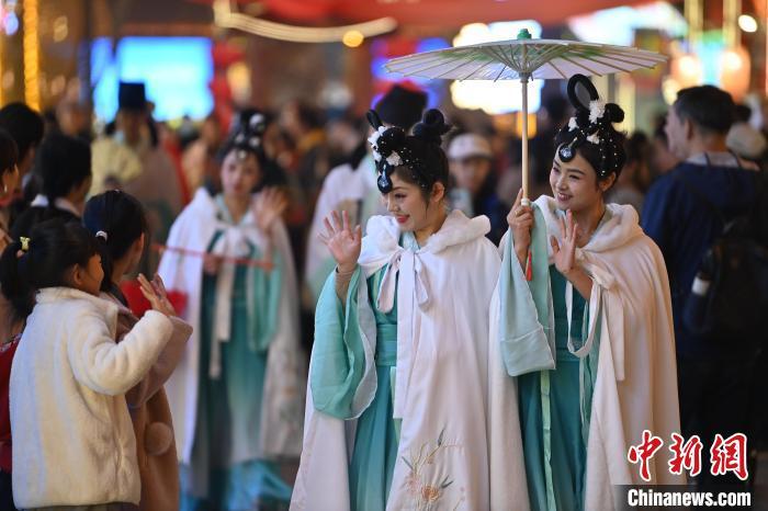 图为街区人员着传统服饰与游人互动。李亚龙摄
