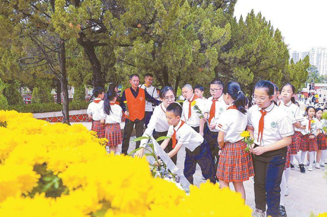 学生向烈士敬献鲜花。(记者 张江毅 摄)