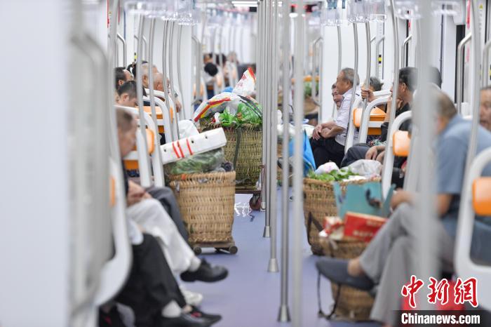 图为菜农们乘坐重庆轨道交通4号线前往市区卖菜。中新网记者何蓬磊 摄