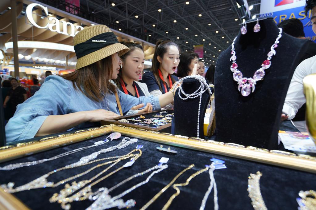  4月15日，參觀者在消博會上選購珠寶首飾。新華社記者 李夢嬌 攝