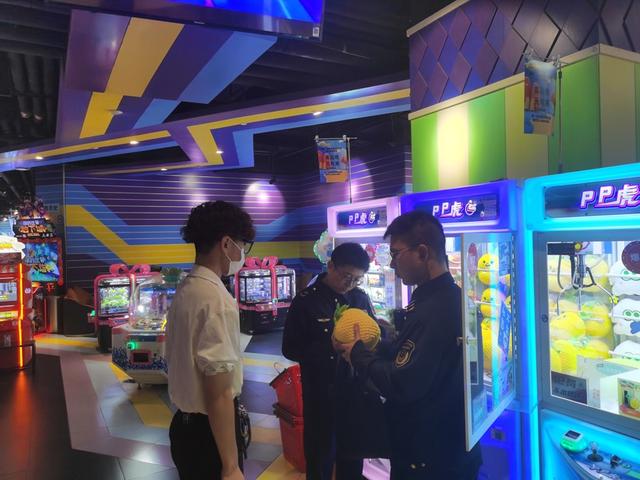 市场监管执法人员检查娃娃机店。 陈玺撼摄