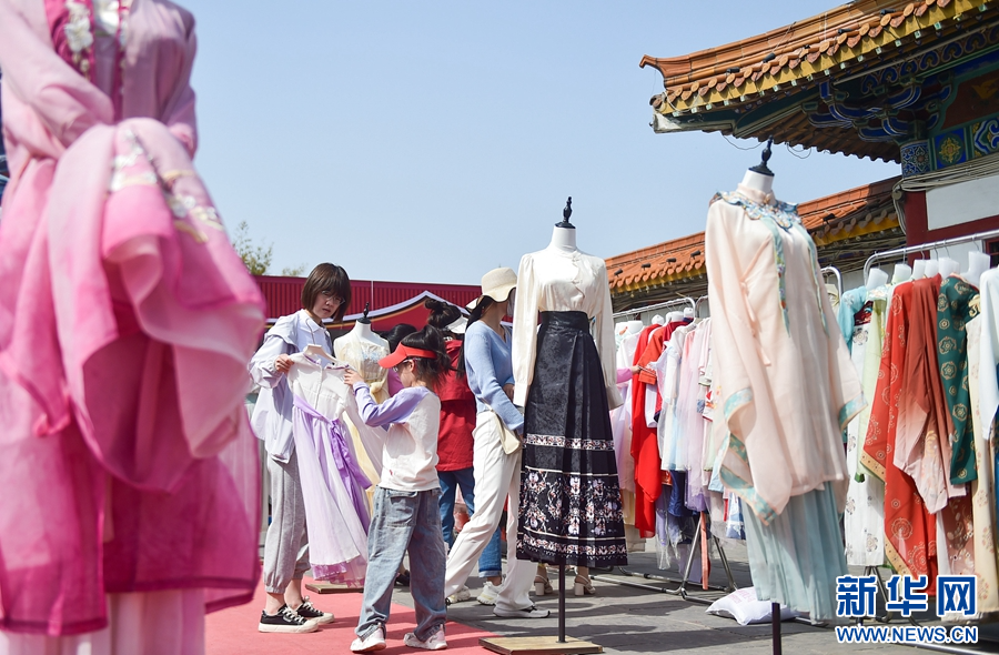   4月14日，在洛陽市中國國花園一家漢服體驗館里，遊客在挑選漢服服飾。