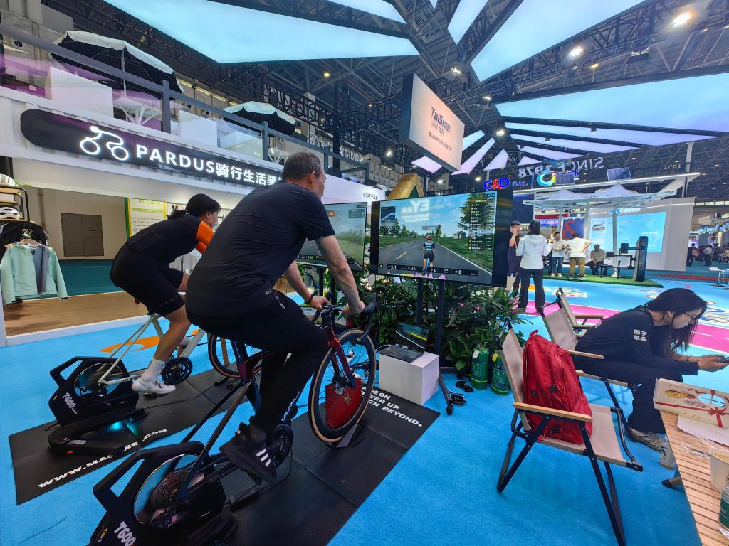 觀眾在第四屆消博會上體驗可模擬各種山地場景騎行的單車。新華社記者吳茂輝 攝