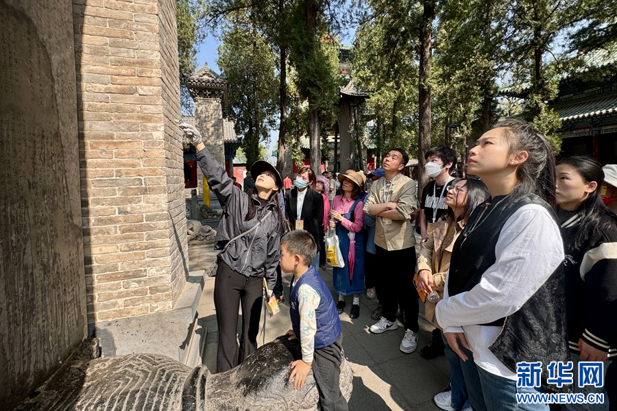 4月12日,在少林寺內,講解員在講述少林寺內石碑的來曆。