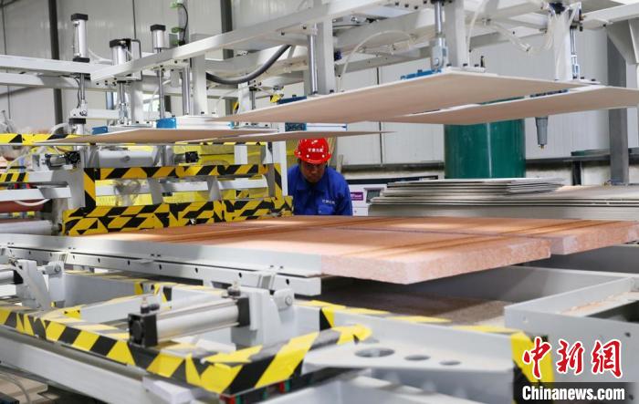 蘭州高新區的甘肅元能新型材料科技有限公司生產車間，工人正在控制機床生產復合牆板。(資料圖)高展 攝