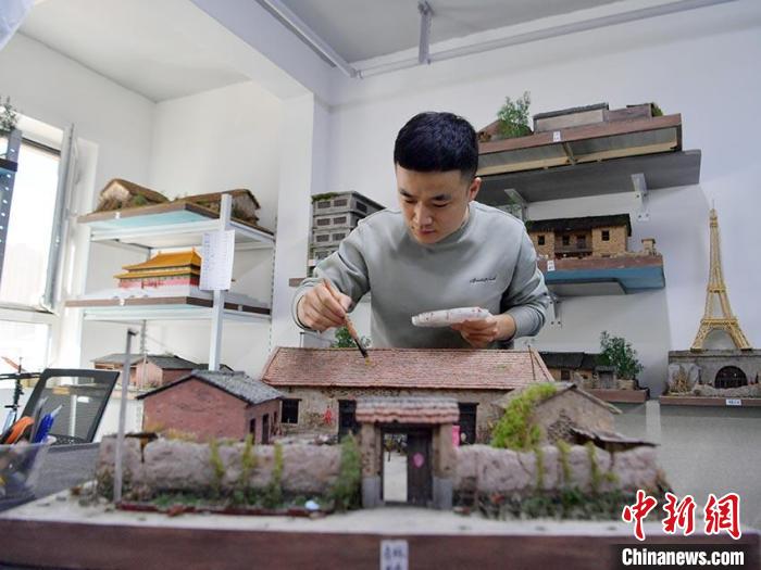 杜春雨正在制作微缩老屋景观。刘栋 摄