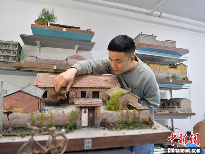 杜春雨正在制作微缩老屋景观。刘栋 摄