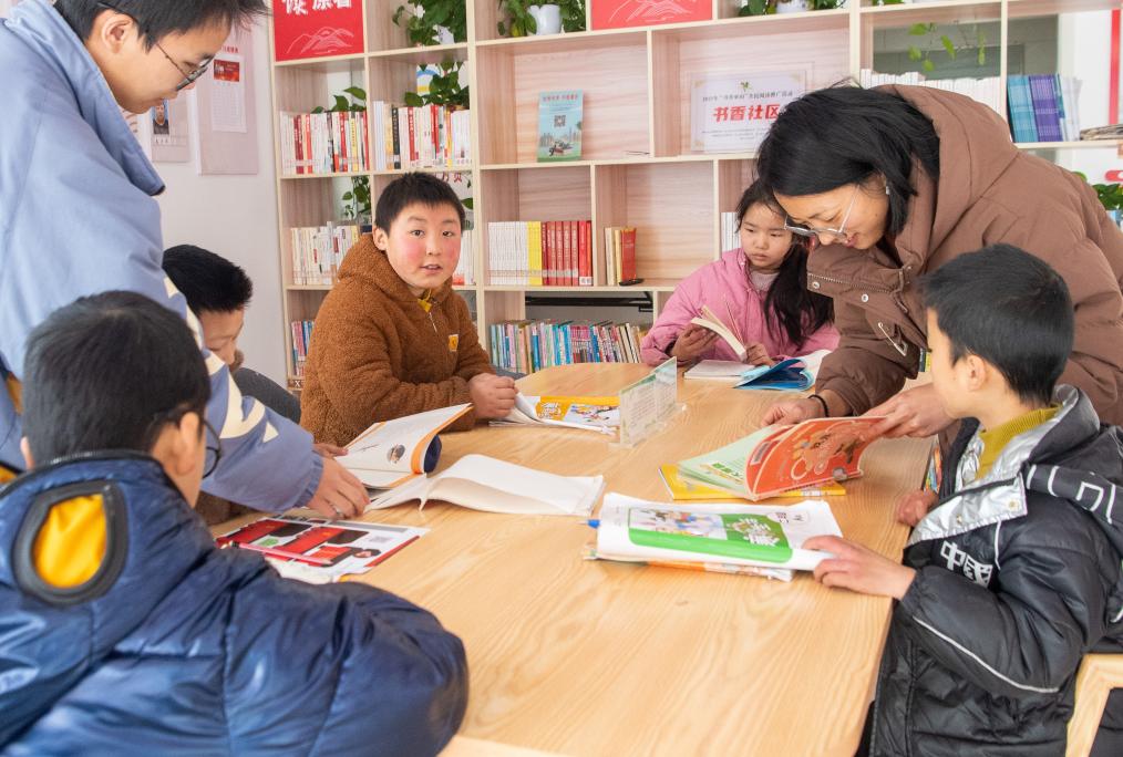  1月24日，在重慶市巫山縣騾坪鎮路口村數字農家書屋內，「臨時家長」和孩子們一起閱讀書籍。新華社記者 唐奕 攝