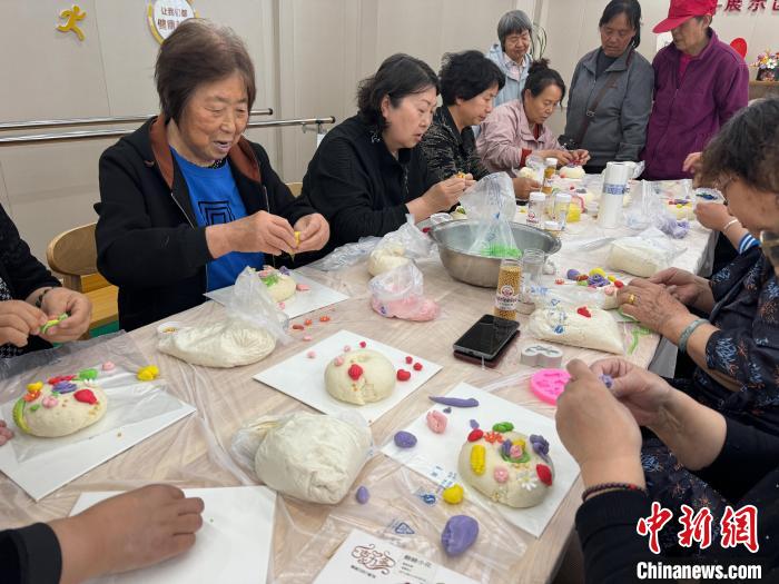 老人們在晉華街道康樂社區居家養老服務中心做面塑。武俊傑 攝