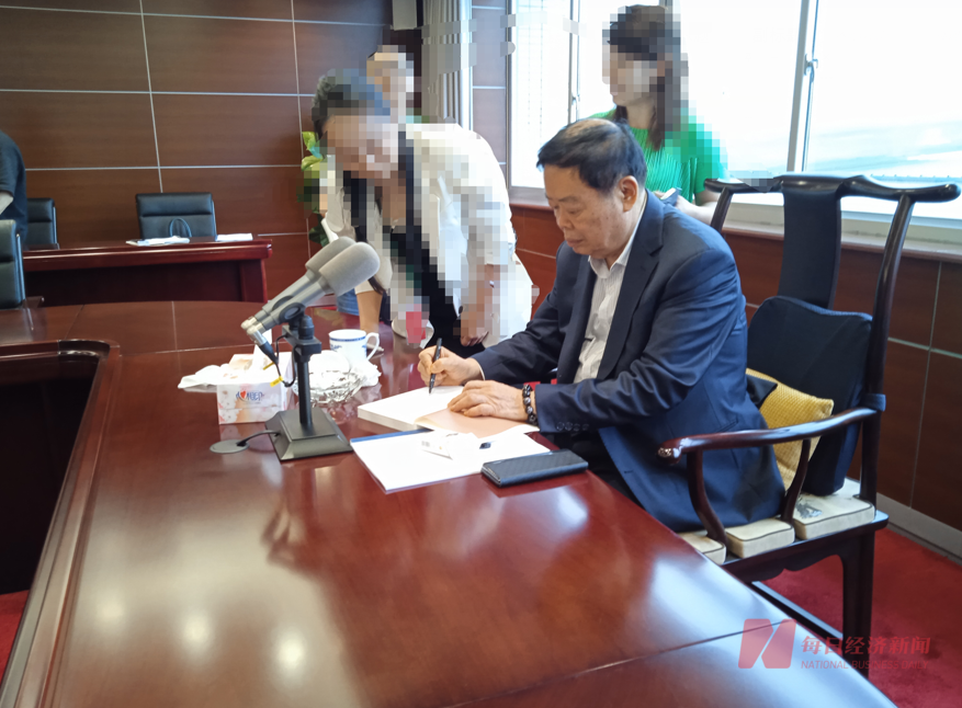 股东大会间歇期间,参会股东请曹德旺对《心若菩提》签名 图片来源:每经记者 赵李南 摄