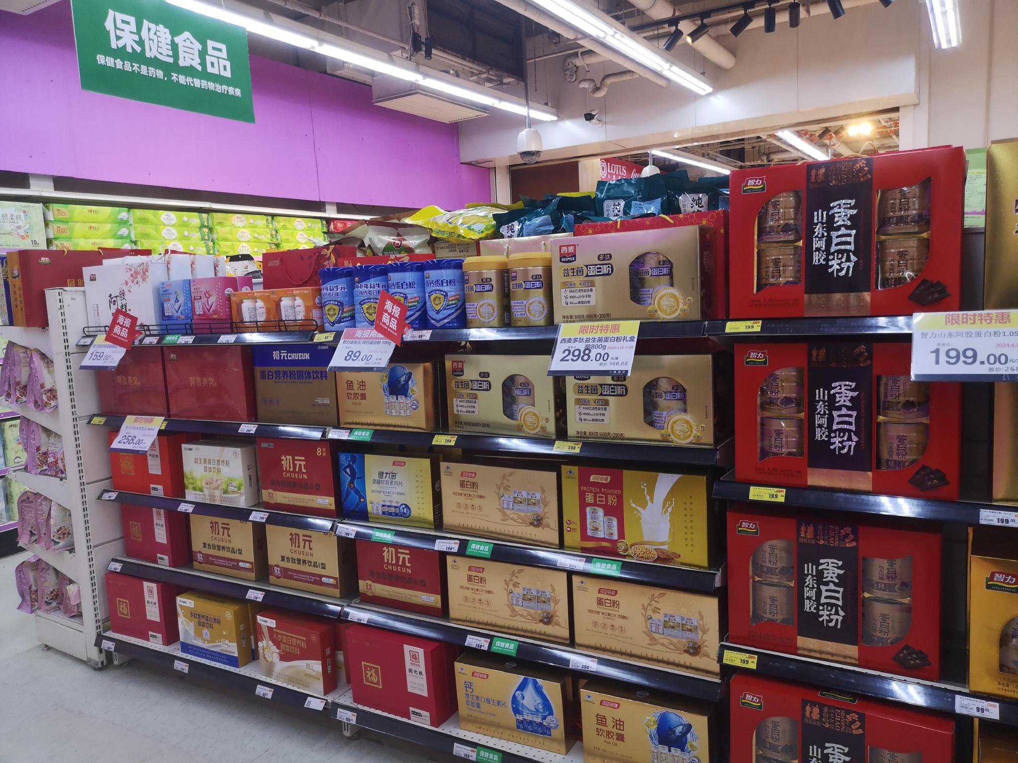 卜蜂莲花超市朝阳路店在保健食品销售专区摆放普通食品,保健食品仅用绿底白字的“保健食品”标签区别。孟刚/摄
