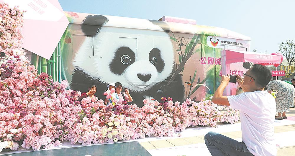 游客在“鲜花巴士”前打卡