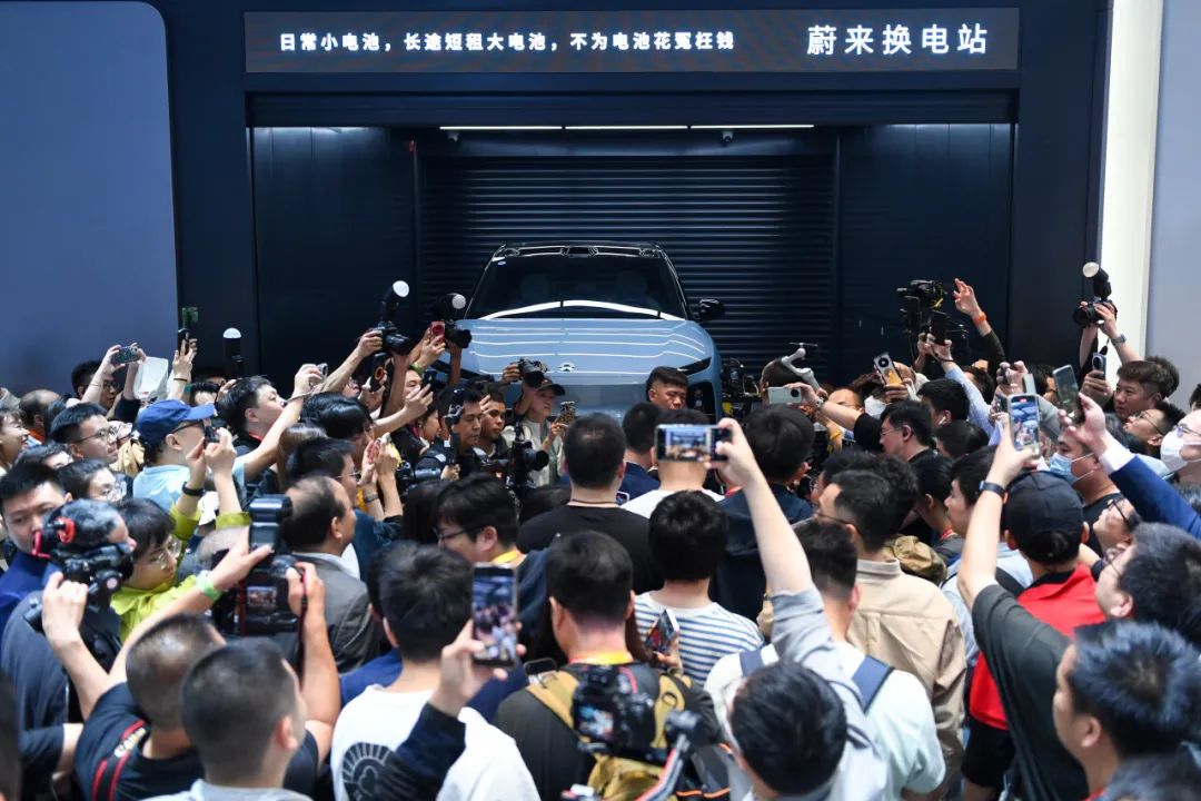 参观者在蔚来汽车展台参观电动汽车换电站演示。鞠焕宗摄(新华社)