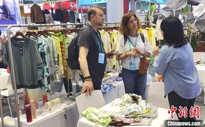 5月3日，廣交會境外採購商與中國企業設計師圍在一起商討衣服的用料和設計。中新社記者 蔡敏婕 攝