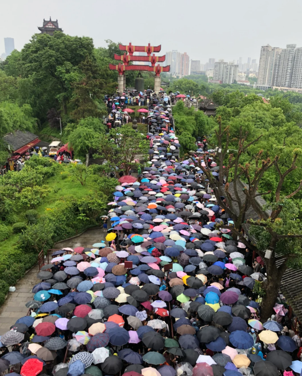 黃鶴樓景區的遊客打著傘排隊參觀