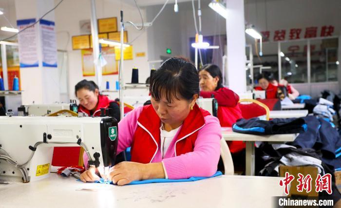 圖為社區居民在製衣工廠工作。(資料圖)艾慶龍 攝
