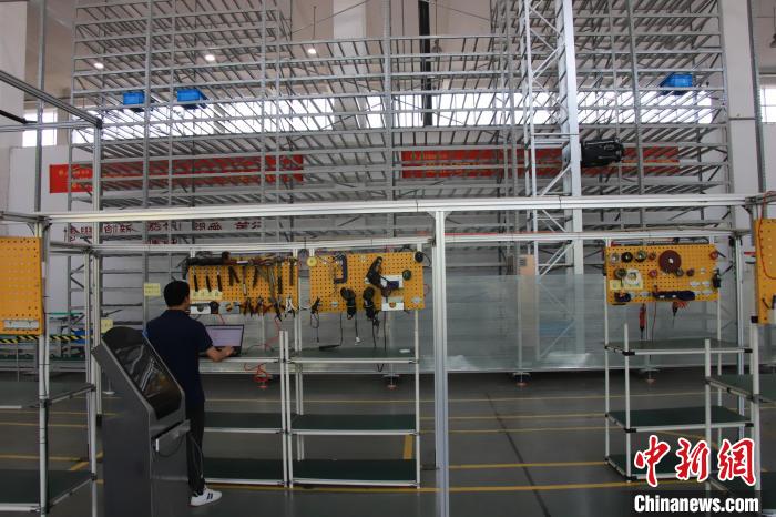 重慶嘉騰機器人自動化有限公司生產車間內工作人員正在測試輕型多料箱堆垛機性能。馬佳欣 攝