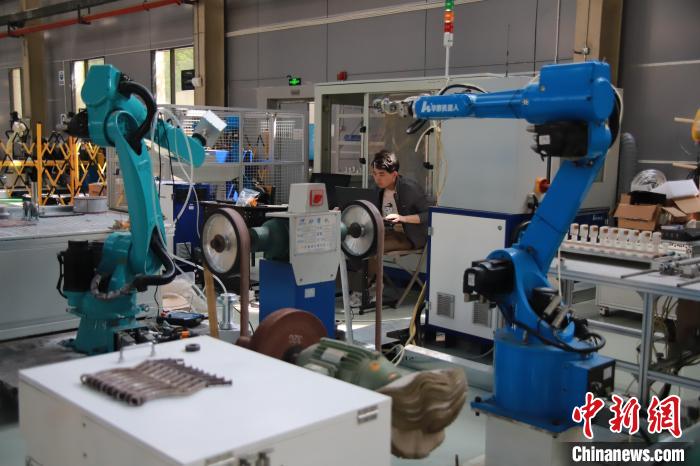 圖為重慶華數機器人有限公司測試車間里工程師正在調試機器人。馬佳欣 攝