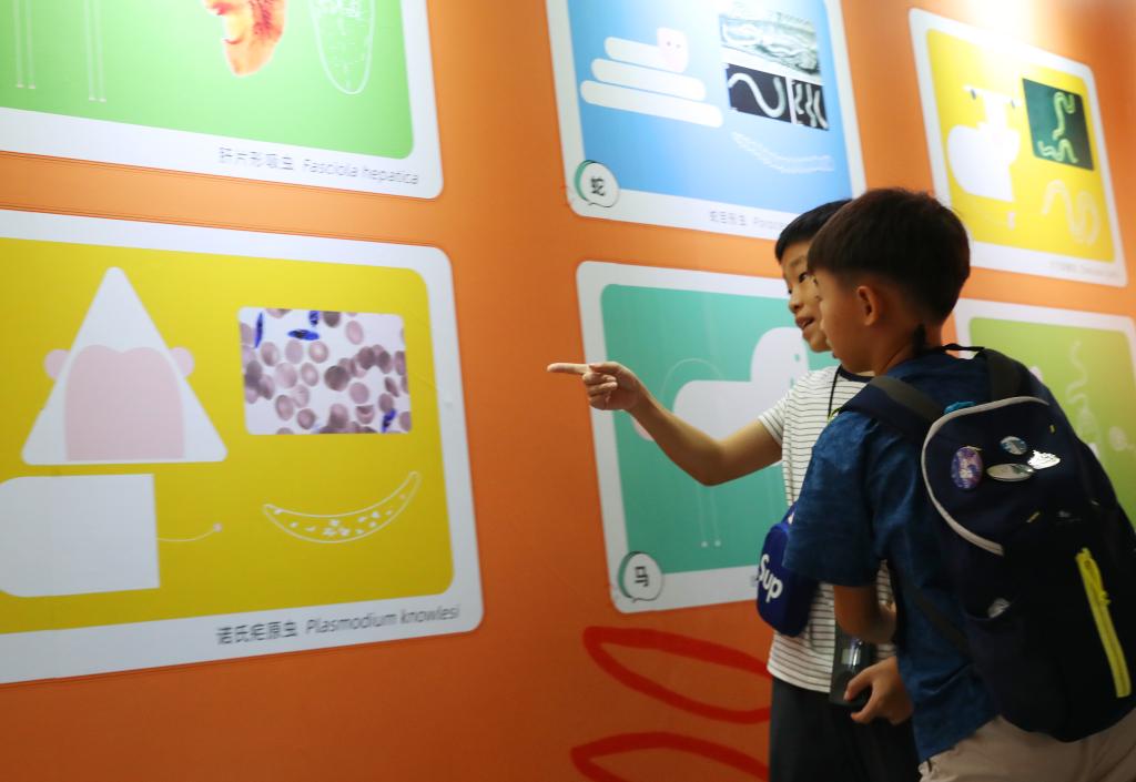   2023年9月2日，小朋友在上海自然博物館「舌尖上的寄生蟲」專題科普展寄生蟲知識展板前參觀。新華社記者方喆 攝
