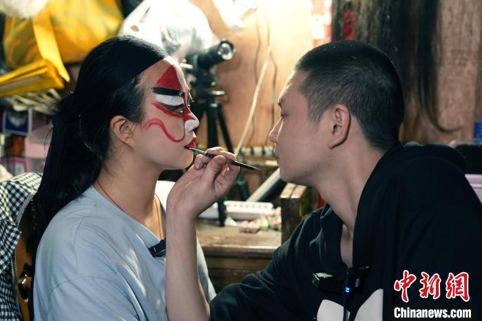 4月25日，四川成都，川劇演員為洪婉晴(左)化妝。安源 攝