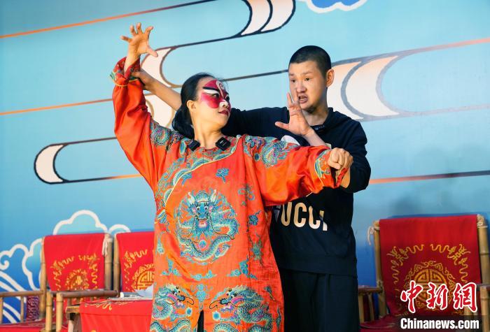 4月25日，四川成都，洪婉晴(左)在川劇演員指導下學習川劇。安源 攝