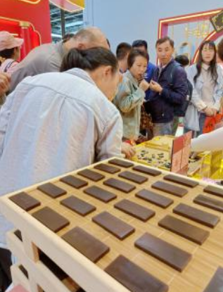▲观众争相品尝同仁堂阿胶糕