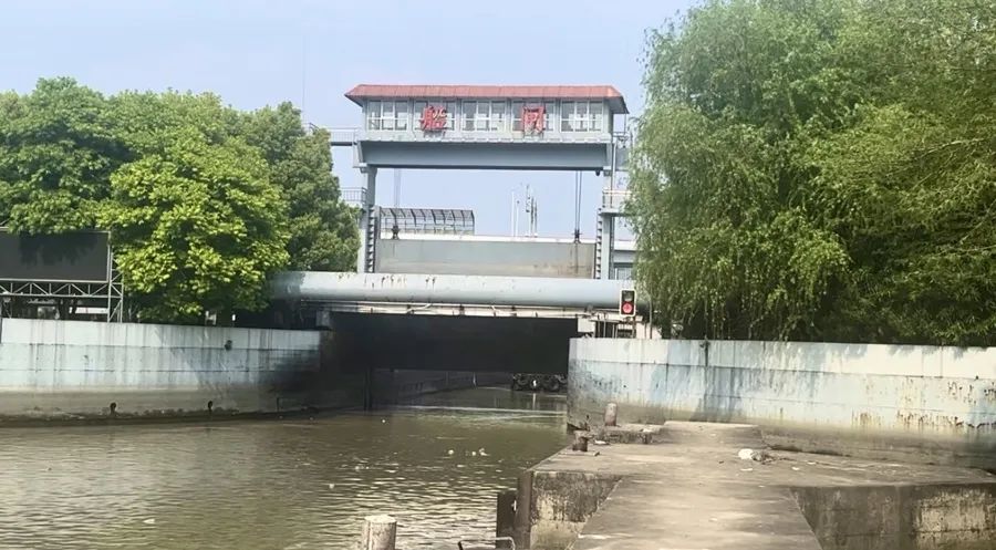 杨思水闸实现单向通行，交通信号灯变换控制船只进出。