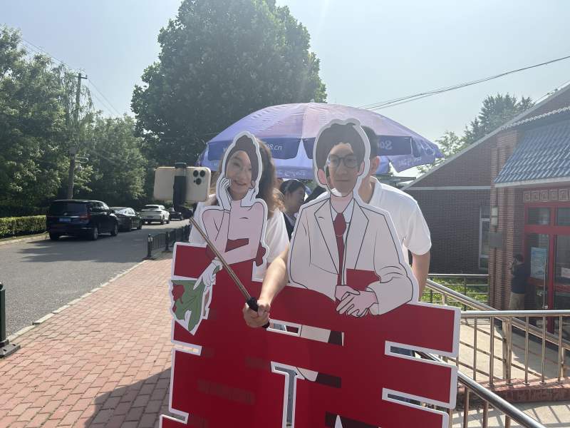 东城区婚姻登记事务中心门口，一对新人在大红“囍”字的打卡点拍照。新京报记者 陈琳 摄