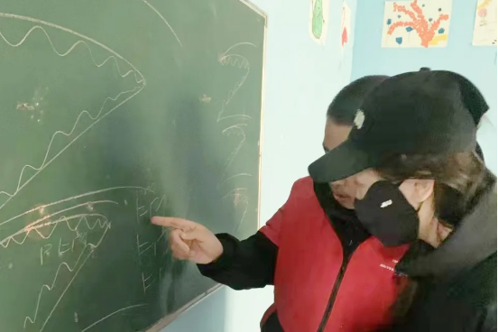 毛毛正在为韩轩展示自己画的鲨鱼