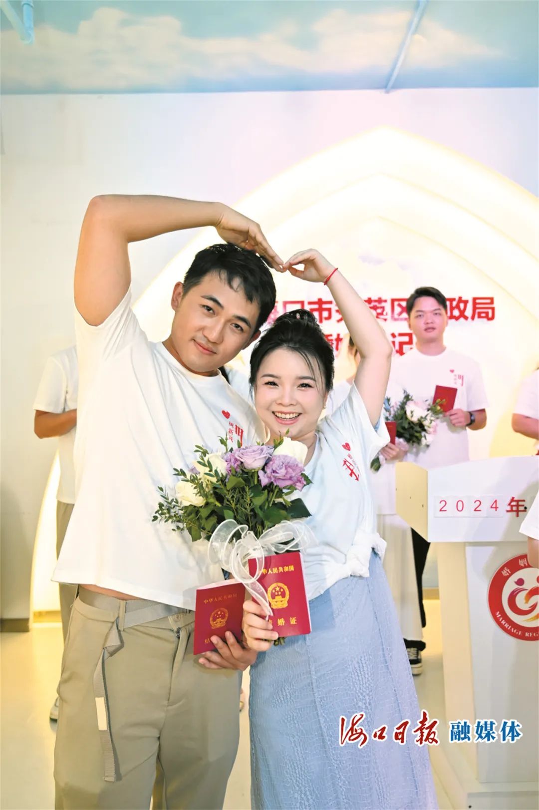 5月20日,秀英区举办结婚登记集体颁证活动,新人们领取结婚证后比心庆祝。海口日报融媒体记者 石中华 摄
