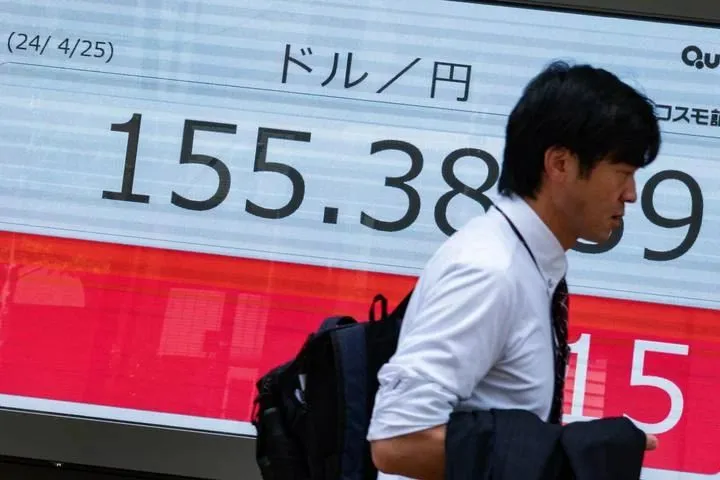4月25日,行人走過日本東京一處顯示實時彙率的電子屏幕。新華社記者 張笑宇 攝
