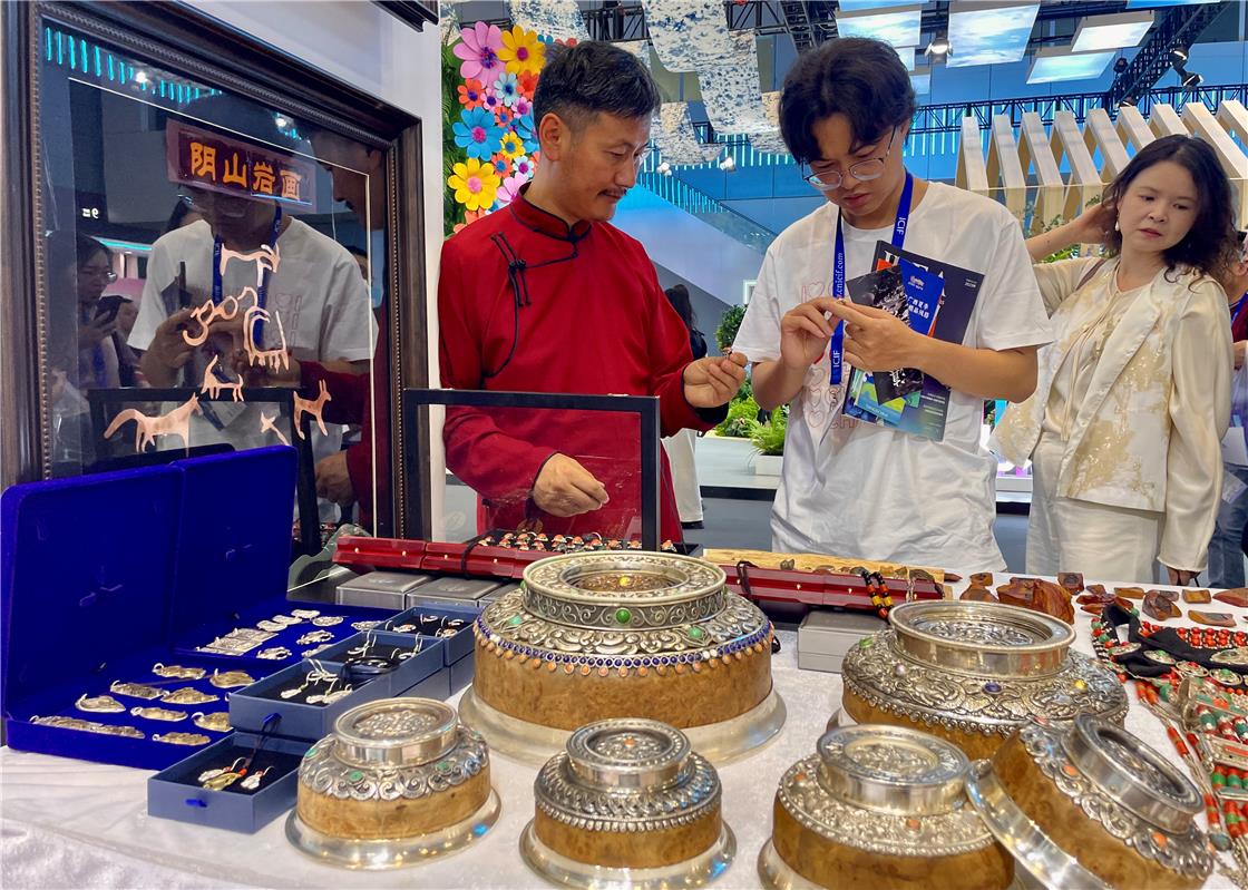 觀眾在內蒙古展區瞭解內蒙古特色文創產品。