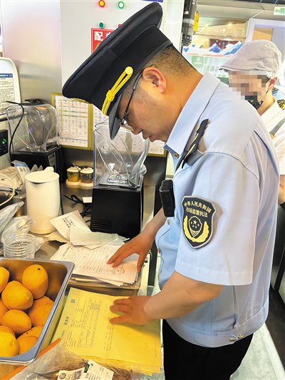 5月27日,石景山区市场监督管理局鲁谷街道所工作人员对茉酸奶北京石景山万达店进货单进行检查。新京报记者 彭镜陶 摄