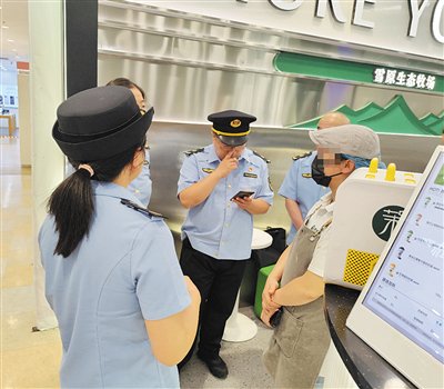 5月27日下午,朝阳区市场监管局执法人员对茉酸奶北京伊藤洋华堂店铺工作人员进行询问。新京报记者 吴梦真 摄