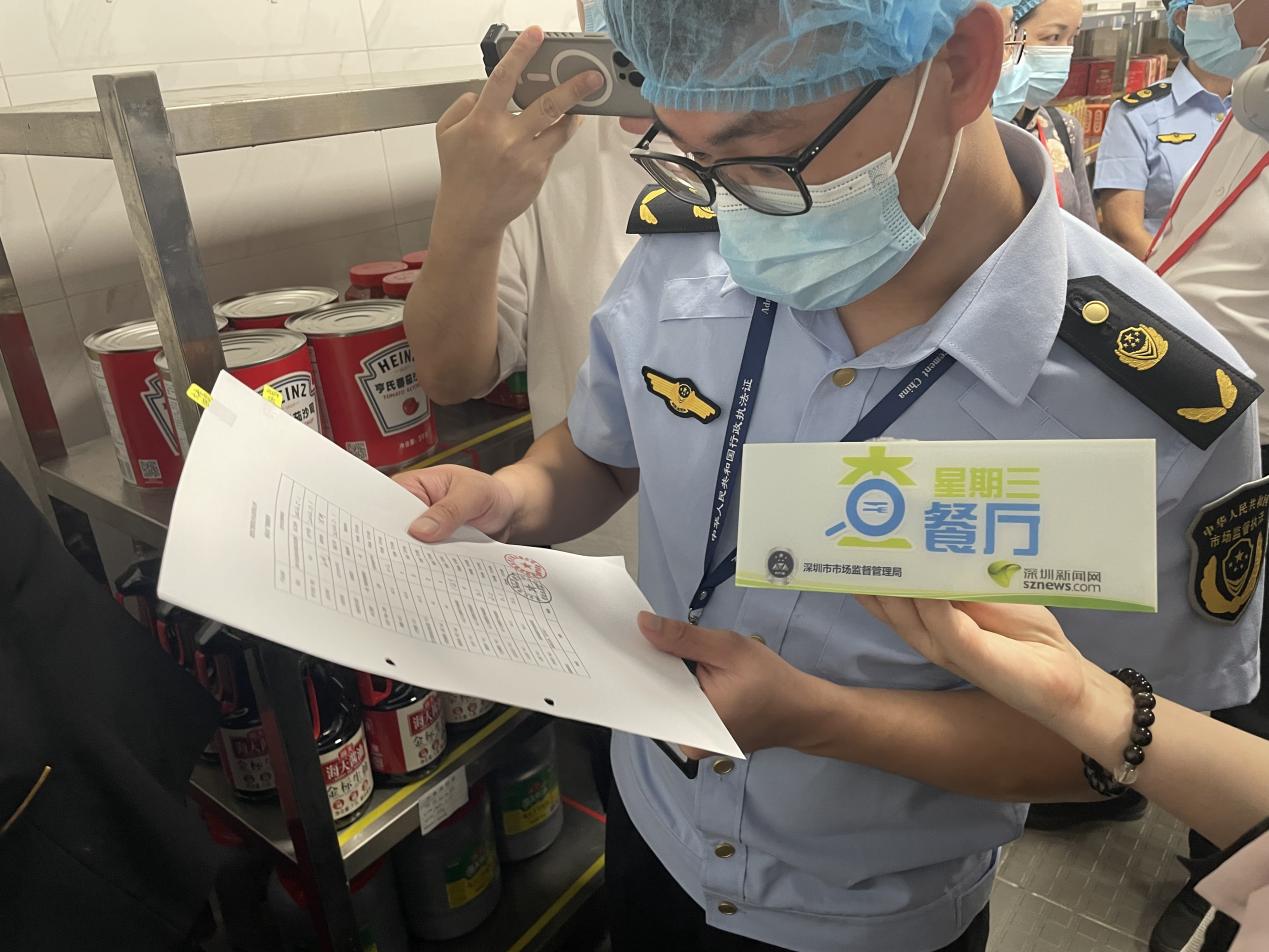 执法人员查看台账情况。