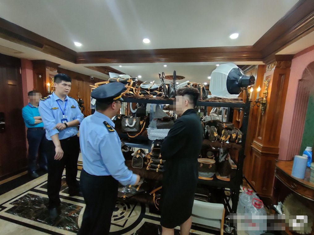 执法人员在售卖假冒奢侈品场所内调查。资料图片