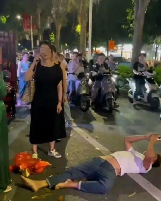 摊贩在没人动他的情况下,直接倒在了地上。视频截图