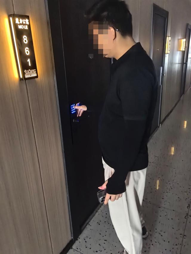△房产中介肖某正在带记者看“魔力公寓”内的空置房,他能熟练地输入密码解开密码锁。