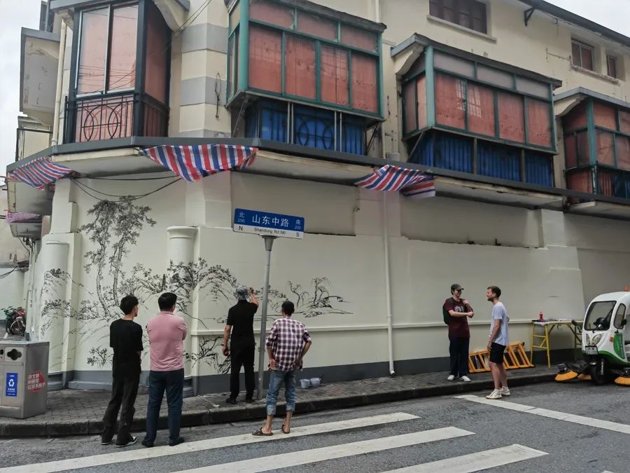 在山东中路一侧的旧改基地外墙，彩绘师正在绘制 唐烨摄