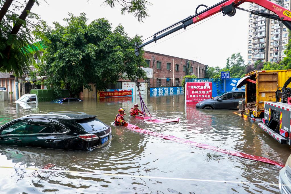 6月21日，在重慶大渡口區雙山路，大渡口區的消防救援人員在積水中使用抽水泵抽取城市道路積水。新華社發（田輝世 攝）