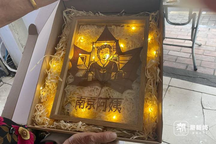 来买咖啡的顾客送韩素珍的树叶雕刻。潮新闻记者 吴馥梅 摄